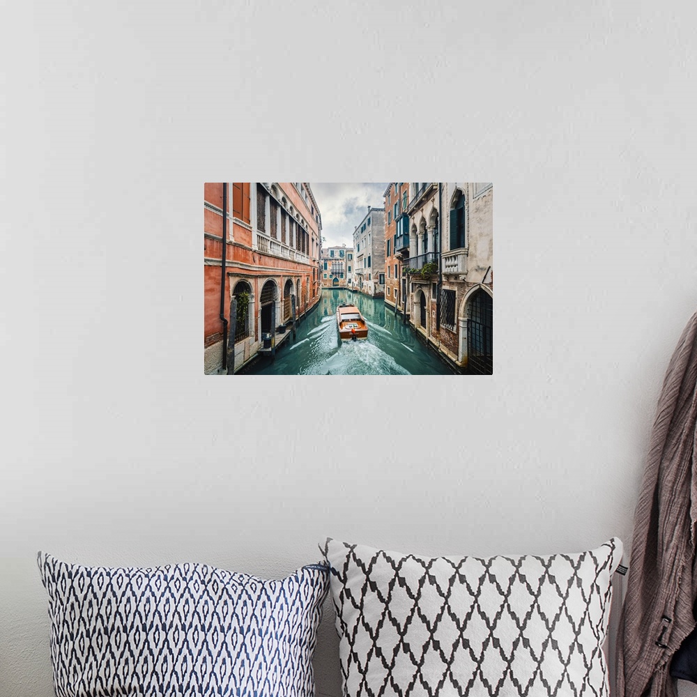 A bohemian room featuring A boat cruising a green canal in Venice, Veneto, Italy