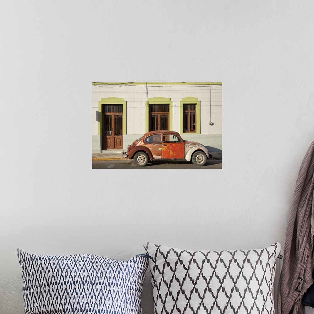 A bohemian room featuring A vintage Volkswagen Beetle in front of a house in Merida, Yucatan, Mexico.