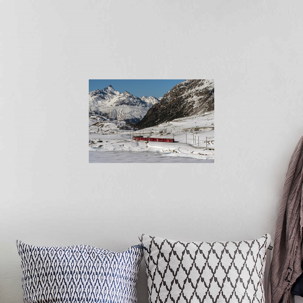 A bohemian room featuring The famous Bernina Express red train passing Lago Bianco in a scenic winter mountain landscape, G...