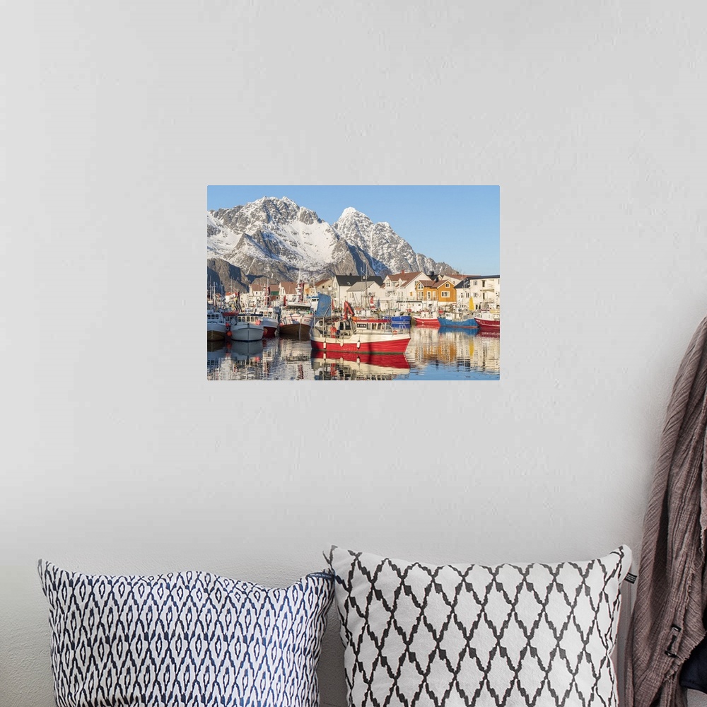 A bohemian room featuring Fishing boats in the harbour, with snowcapped mountains in the background. Henningsvaer, Nordland...