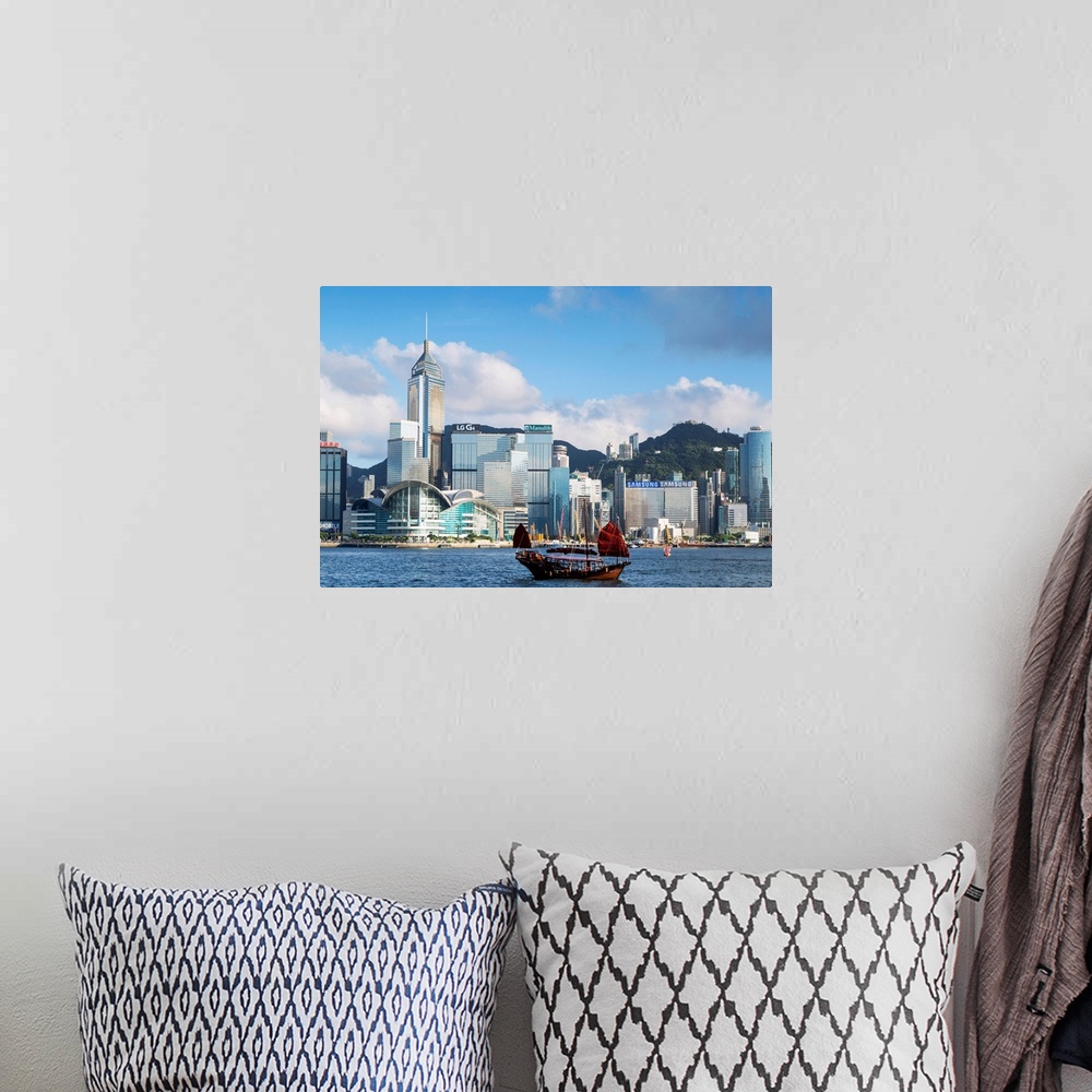 A bohemian room featuring Junk boat passing Convention Centre and Hong Kong Island skyline, Hong Kong, China.