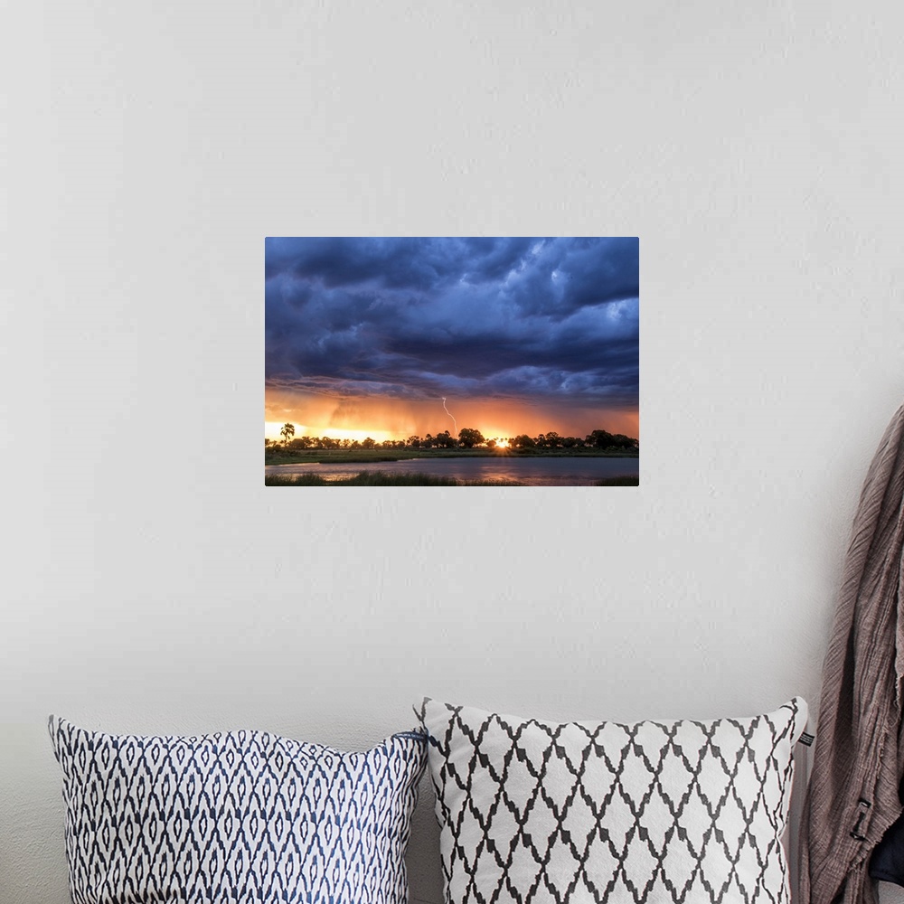 A bohemian room featuring Lightning shoots from a summer thunderstorm as the sun sets behind it, Okavango Delta, Botswana