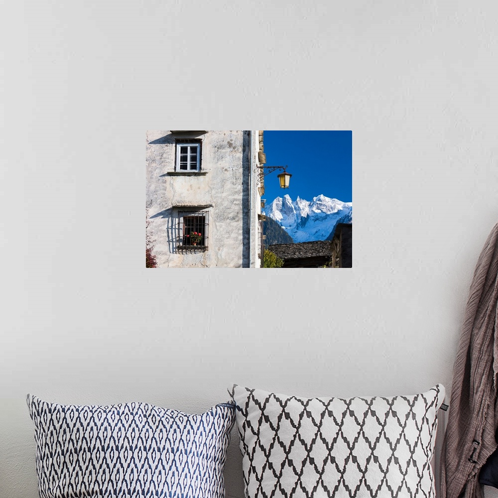A bohemian room featuring Typical alpine house and street lantern frame the snowy peaks Soglio Bregaglia Valley canton of G...