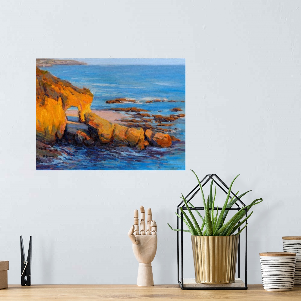 A bohemian room featuring Horizontal contemporary painting of a rocky cliff and a beach with vivid blue water.