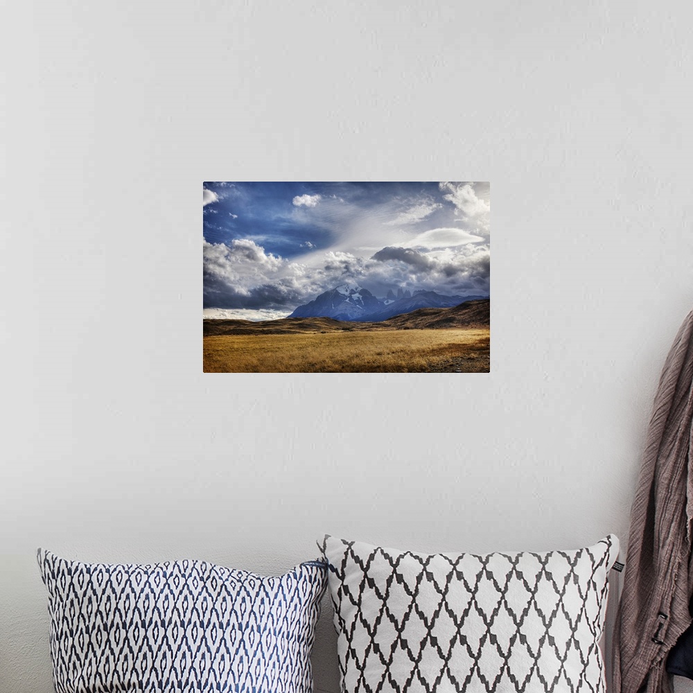 A bohemian room featuring Dramatic photograph of a clouds over a mountain range in the wilderness.