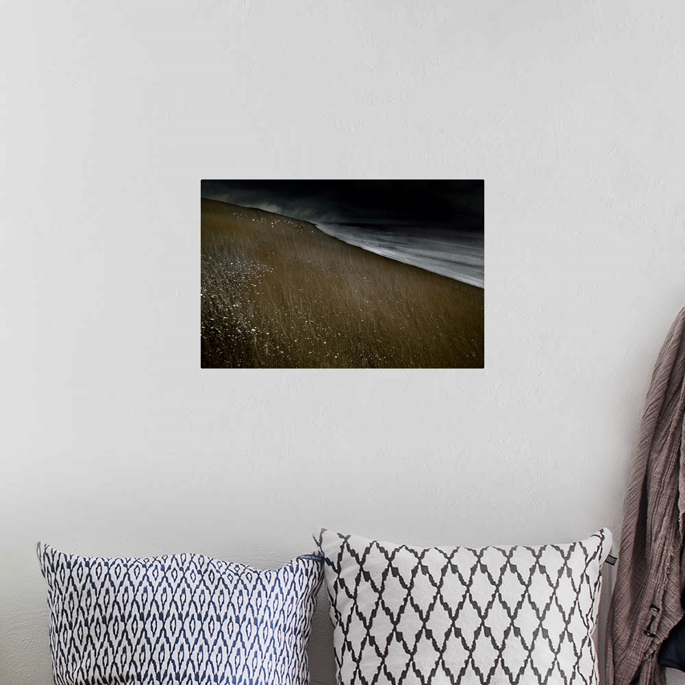 A bohemian room featuring Abstract photograph of a beach landscape with dark ocean waves crashing on a dark sandy beach wit...