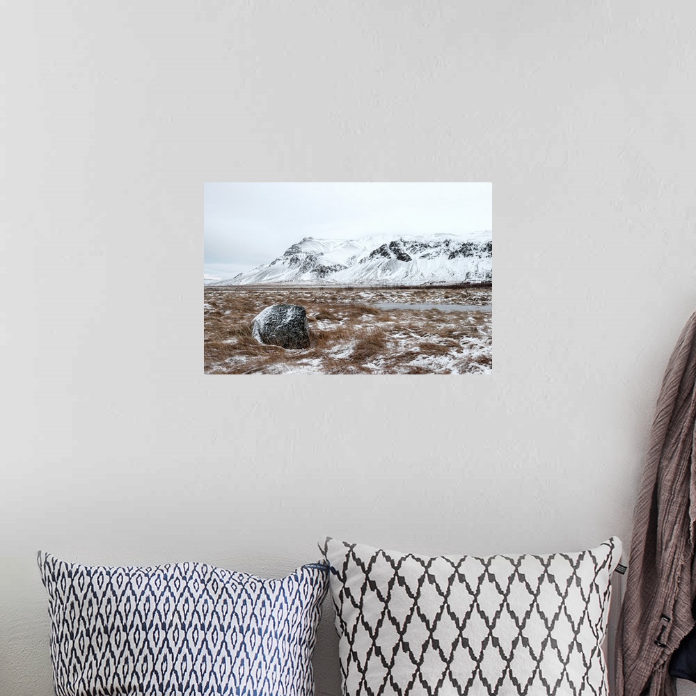 A bohemian room featuring A photograph of a mountain landscape partially covered in snow.