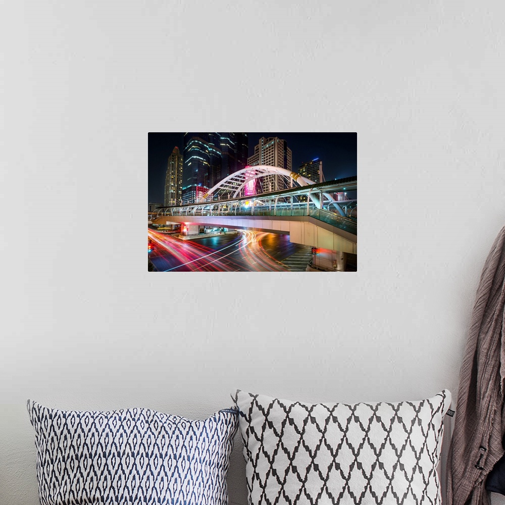 A bohemian room featuring Pedestrian bridgein Bangkok, Thailand, illuminated at night from light trails in the city.
