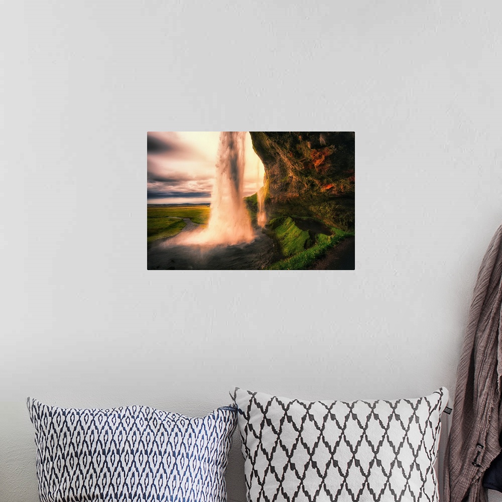 A bohemian room featuring View of the Seljalandsfoss Waterfall Behind from a Cave at Sunset, Iceland