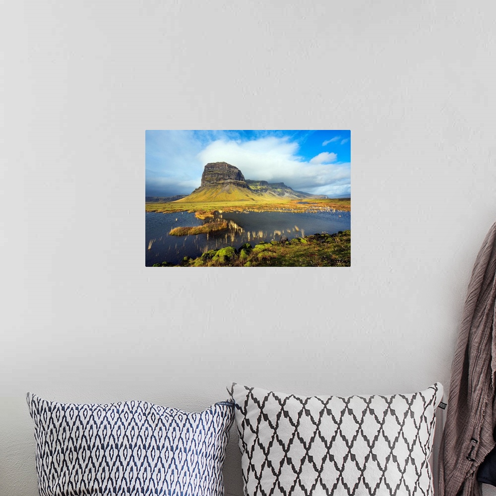 A bohemian room featuring Fine art photograph of the Icelandic landscape with a tall mountain surrounded by clouds.
