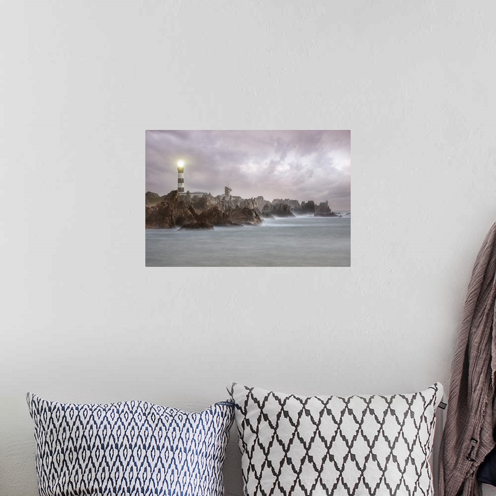 A bohemian room featuring A photograph of a lighthouse on the coast of France.