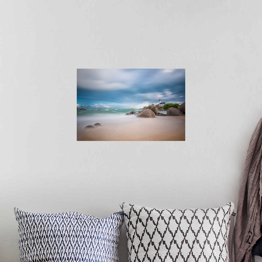 A bohemian room featuring A photograph of the French coast under a blanket of soft clouds.