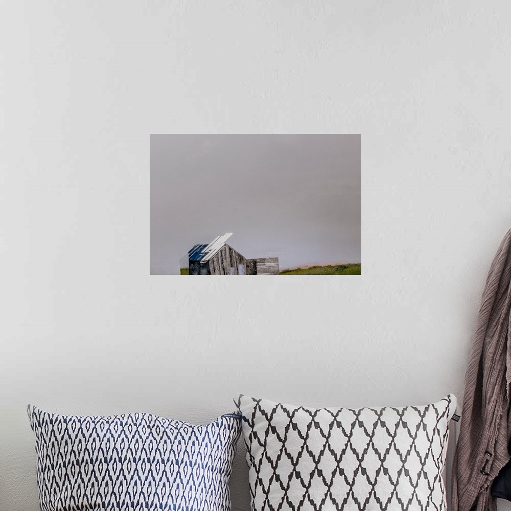 A bohemian room featuring Contemporary artwork of a distorted cabin under a gray sky.