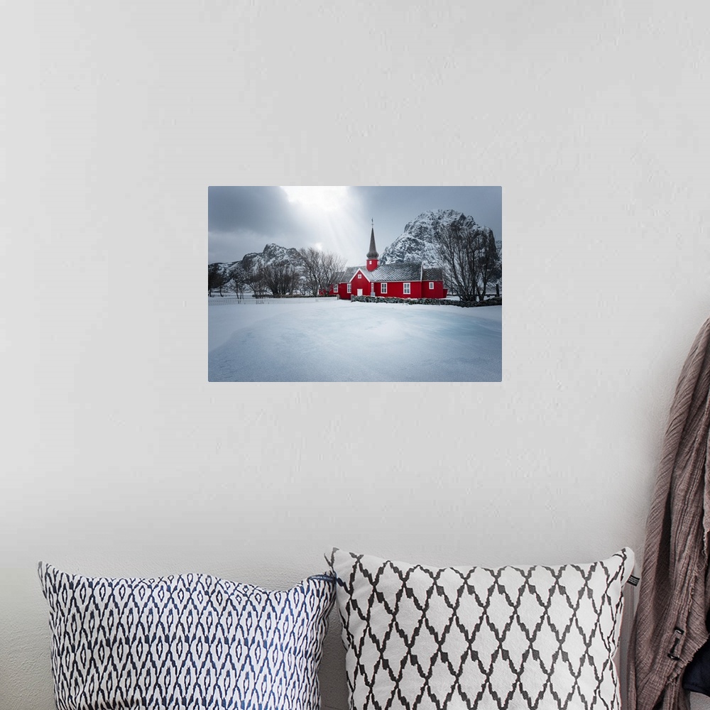 A bohemian room featuring A photograph of red church seen in a wintry landscape.