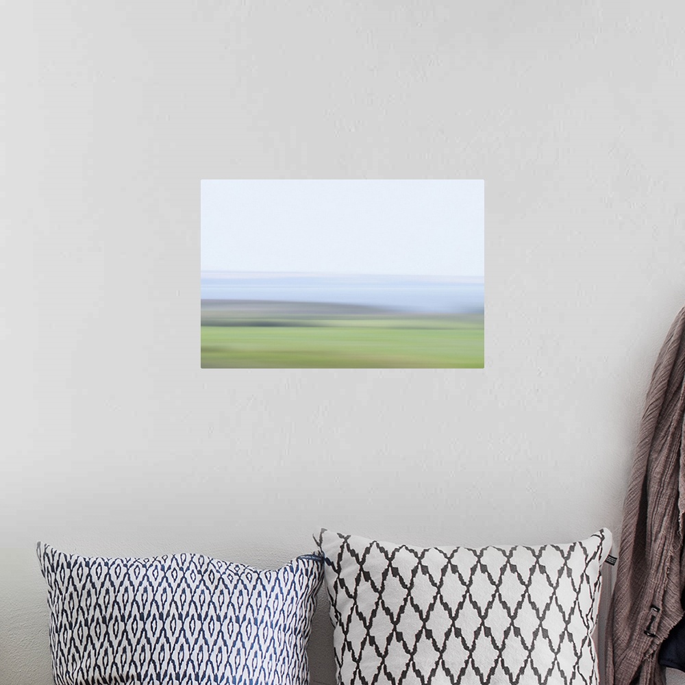 A bohemian room featuring Artistically blurred photo. Delicate colors of a lake and fields early on a hazy morning.