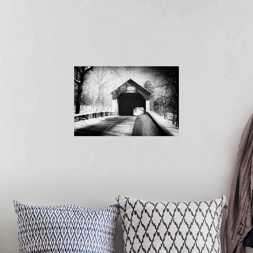 A bohemian room featuring A black and white image of Frankenfield Covered Bridge in Pennsylvania, with a light snowfall.