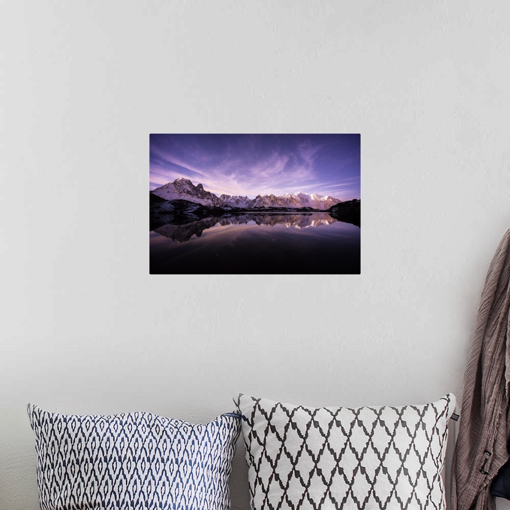 A bohemian room featuring A photograph of the French Alps under a purple sky at dusk.