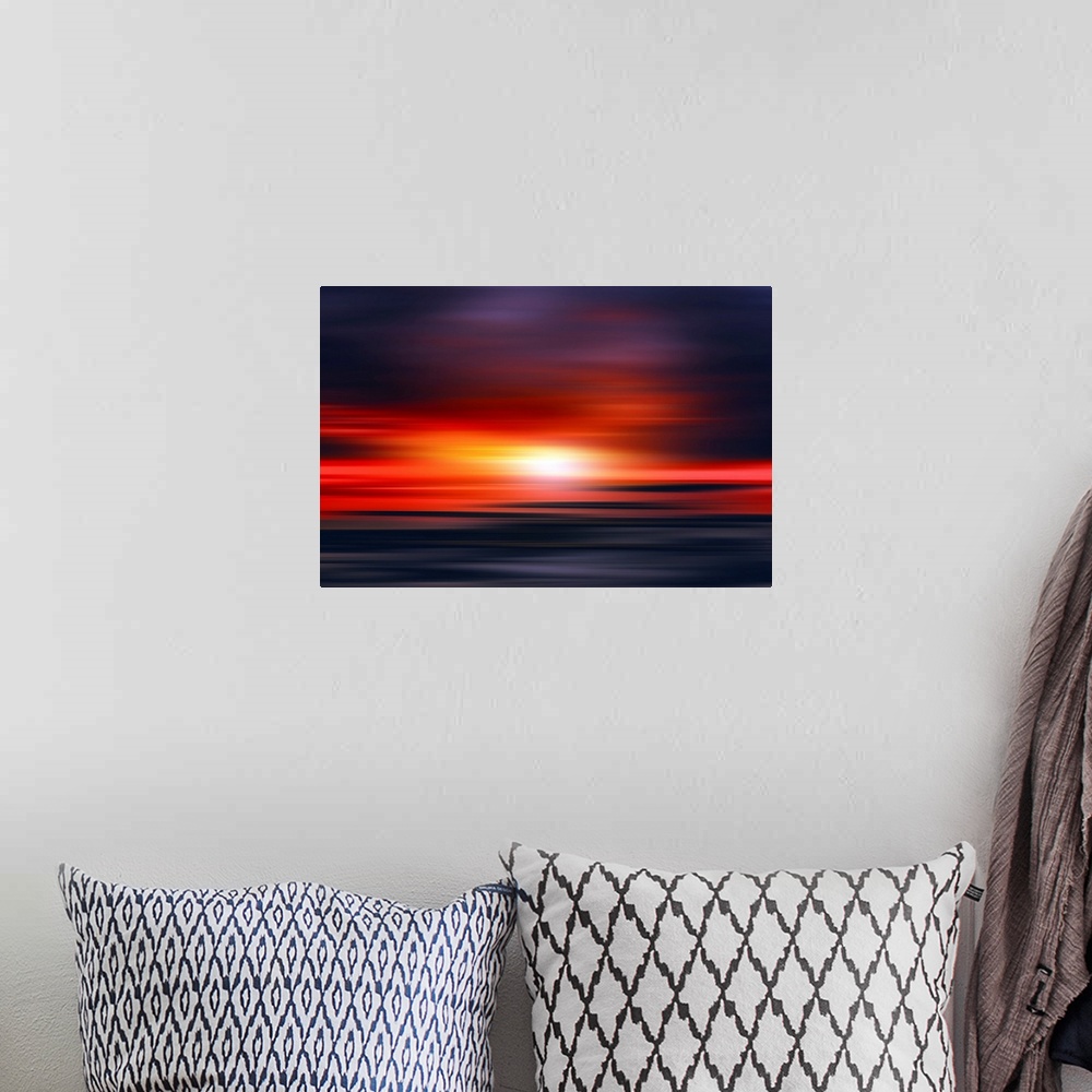 A bohemian room featuring Abstract photograph of a bright red sunset with contrasting dark purple and blue hues above and b...