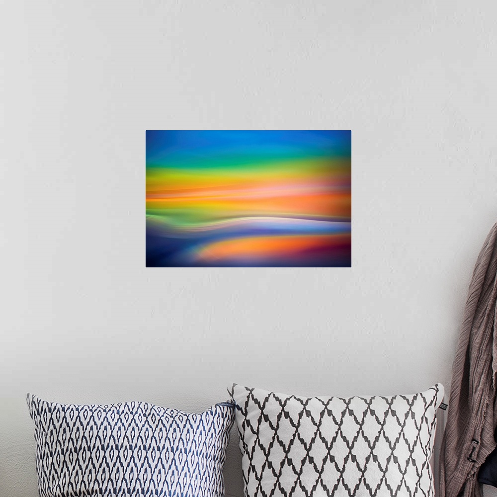 A bohemian room featuring Abstract art with colorful soft focused waves of color running horizontally across the canvas in ...