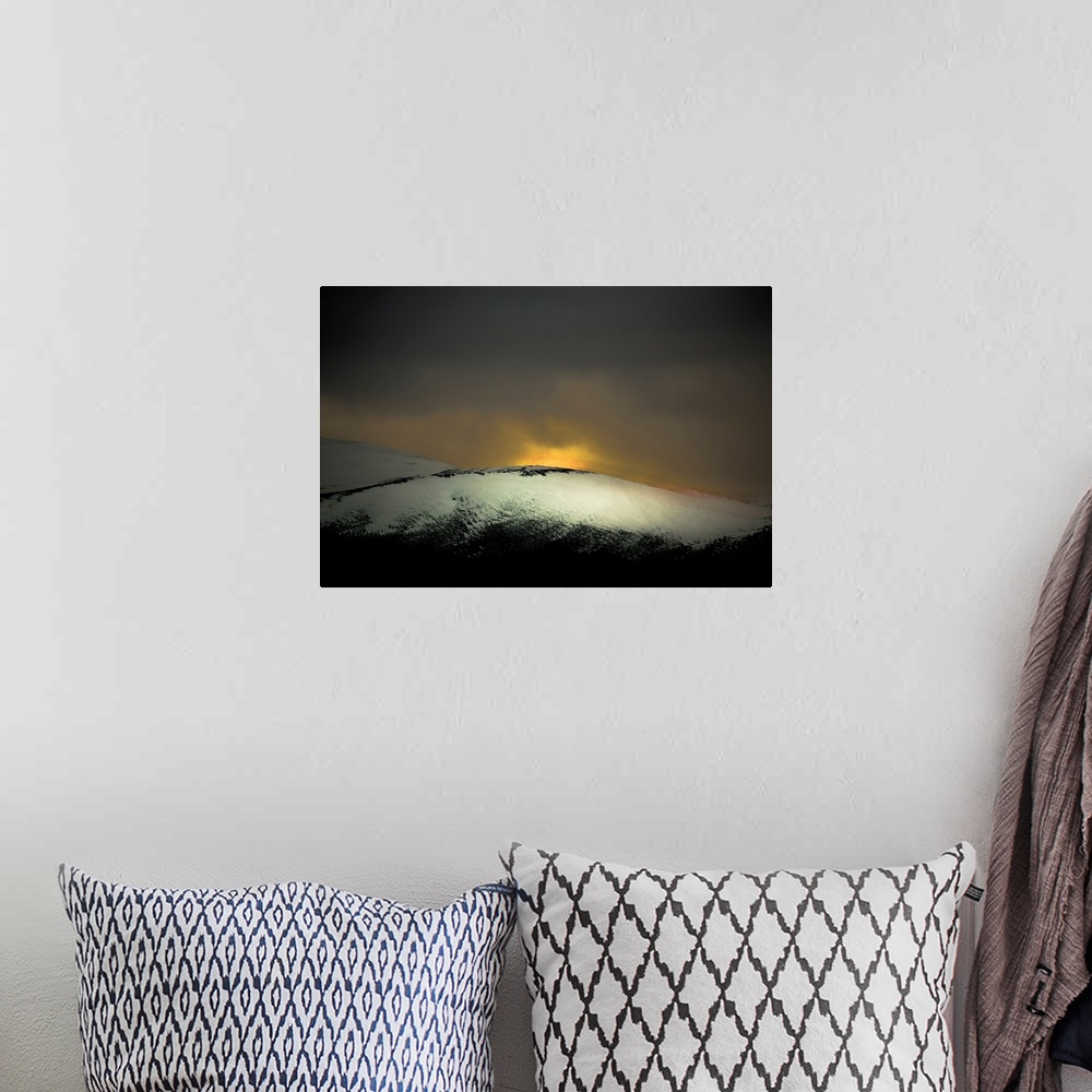 A bohemian room featuring A distressed photo a snow covered hill with dawn rising above it.