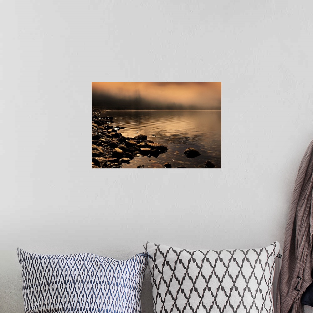 A bohemian room featuring Landscape photograph of a rocky shore with orange fog covering the background.