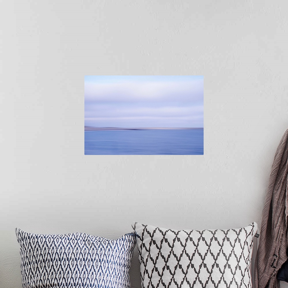 A bohemian room featuring Artistically blurred photo. View on the beach and dunes of the North Sea; land and sea in an inev...
