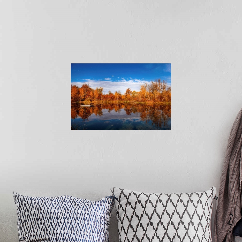 A bohemian room featuring Autumn scenery around a lake under a beautiful blue sky