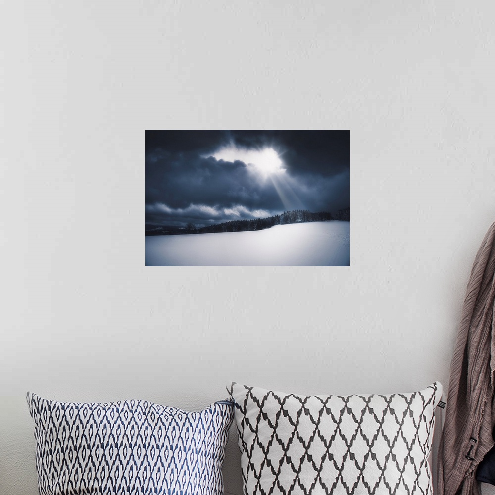 A bohemian room featuring Snowy landscape lit by the sun piercing a stormy sky