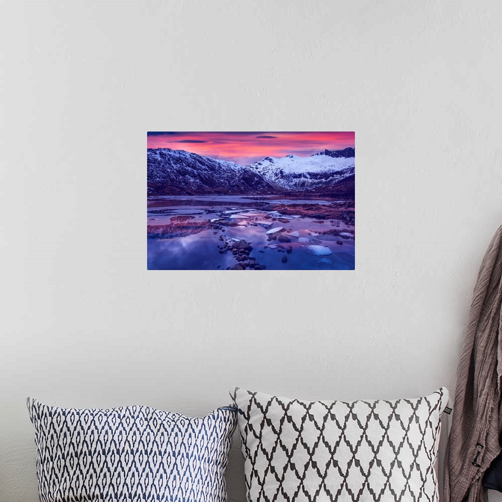 A bohemian room featuring Snowy mountains in Lofoten, Norway, by a glacial lake at sunset.