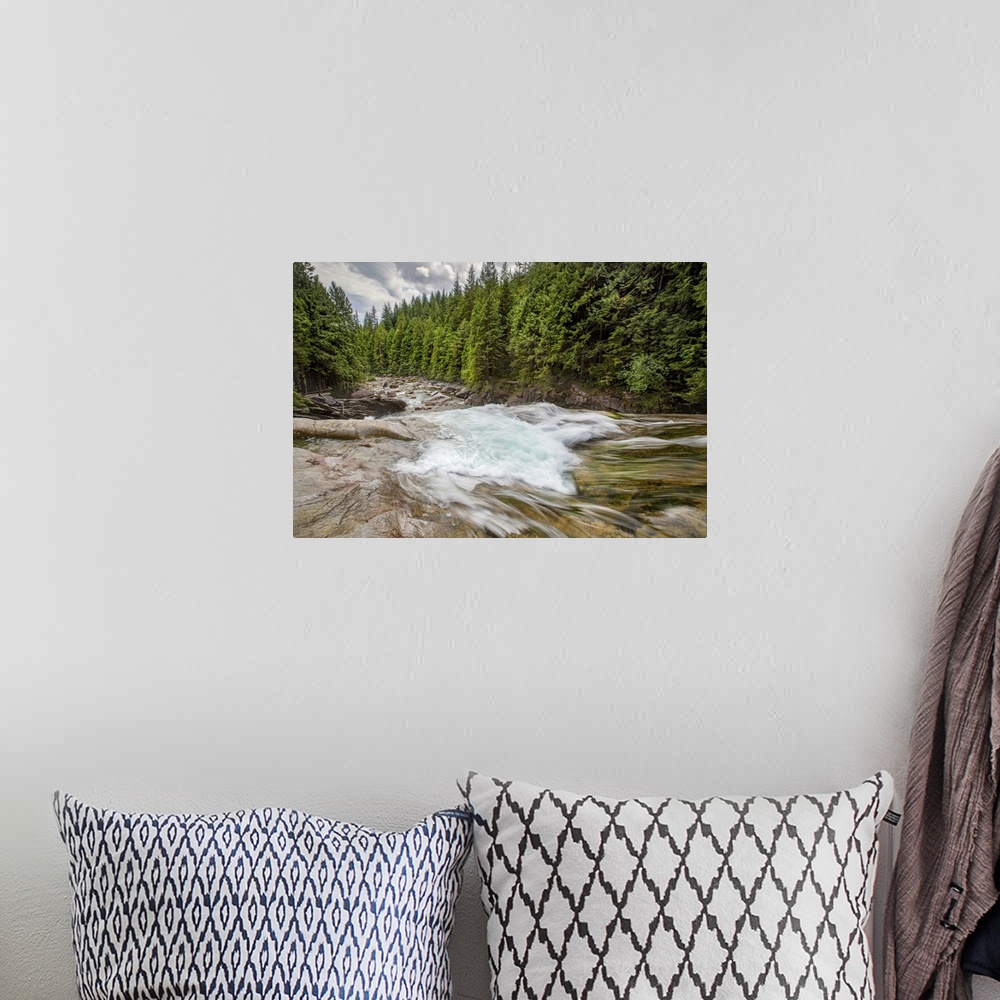 A bohemian room featuring A long exposure of a rushing river through a forest.