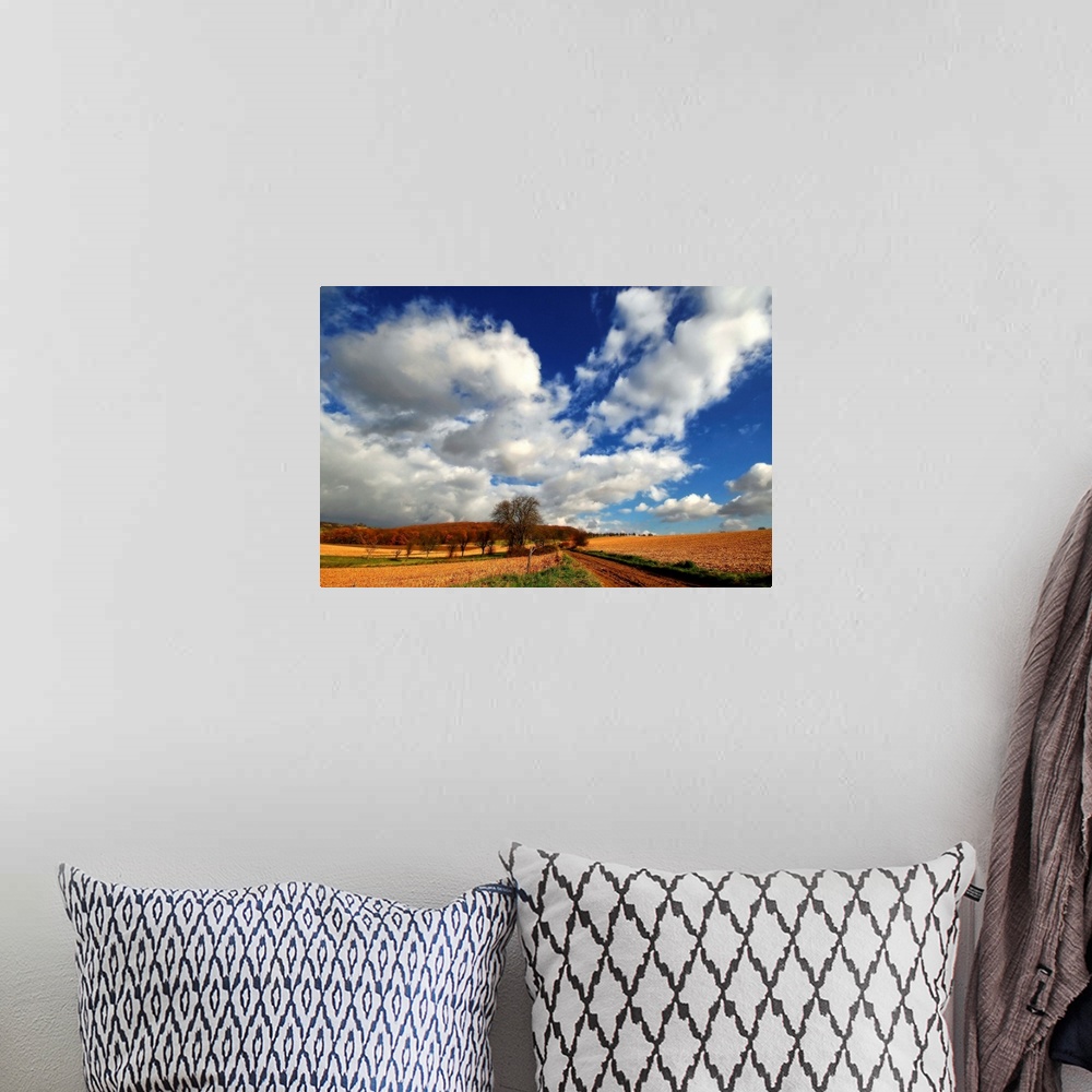 A bohemian room featuring Blue sky with heavy clouds above the countryside