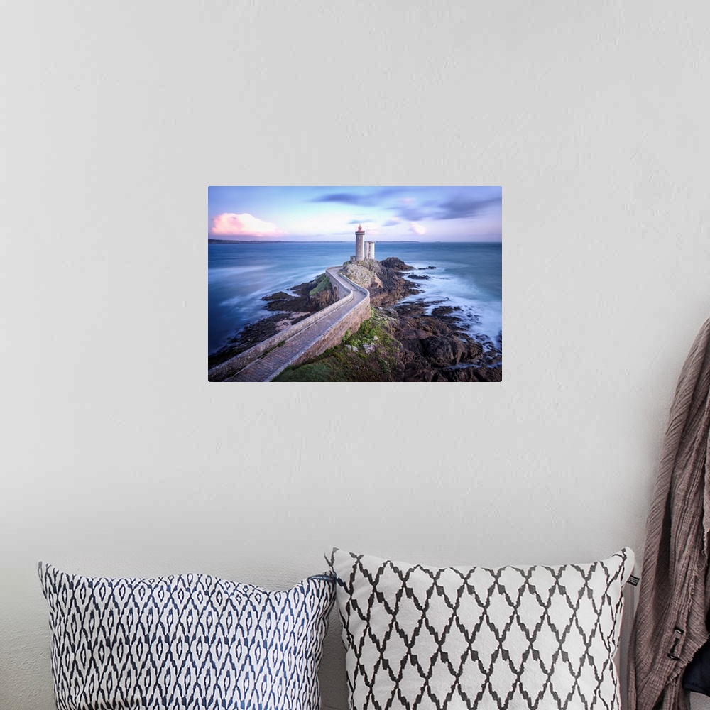A bohemian room featuring Fine art photo of a lighthouse at the end of a rocky peninsula in France.