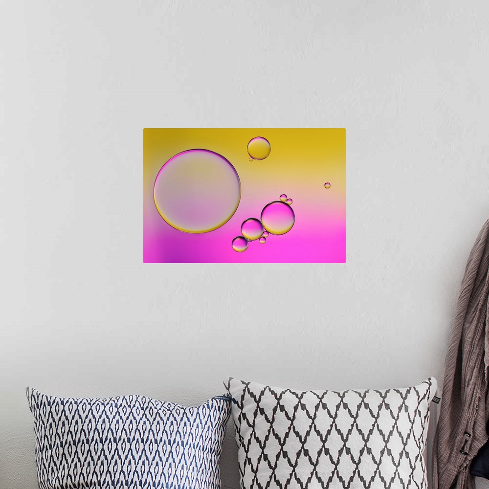 A bohemian room featuring Closeup photograph of drops of oil in water with yellow and pink hues.