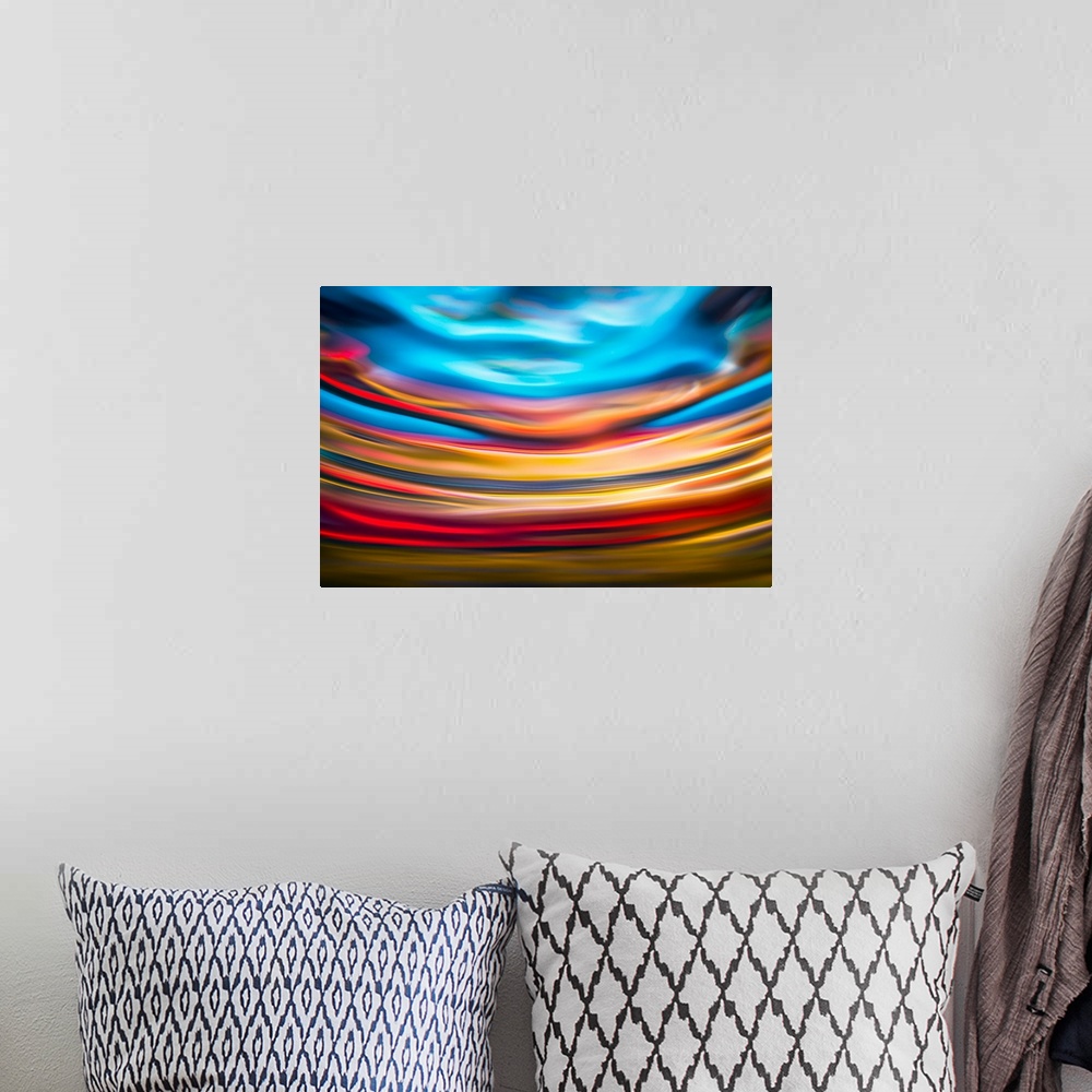 A bohemian room featuring Abstract photograph with arched lines in hues of yellow, red, and blue.