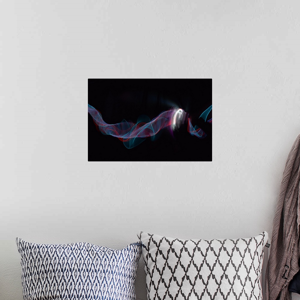 A bohemian room featuring Abstract image created by trailing blue and red lights, resembling wisps of smoke.