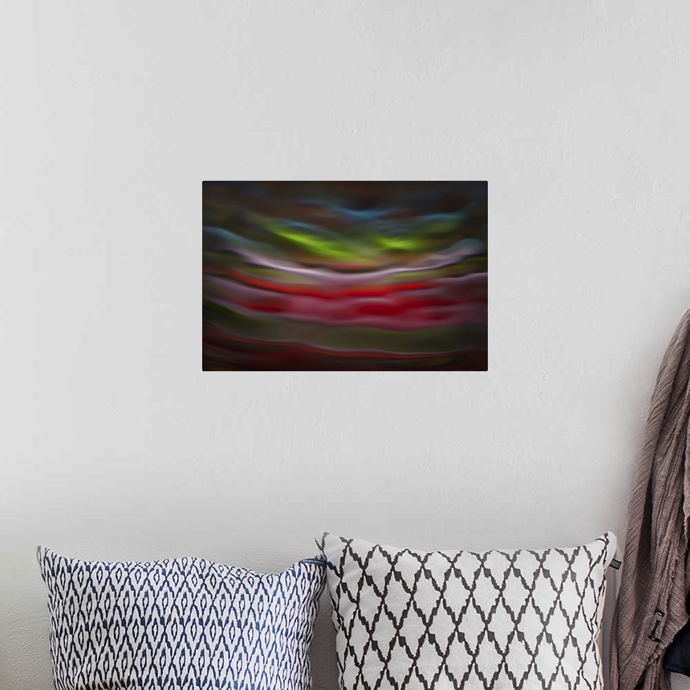 A bohemian room featuring Abstract photograph in green and red shades resembling ocean waves.