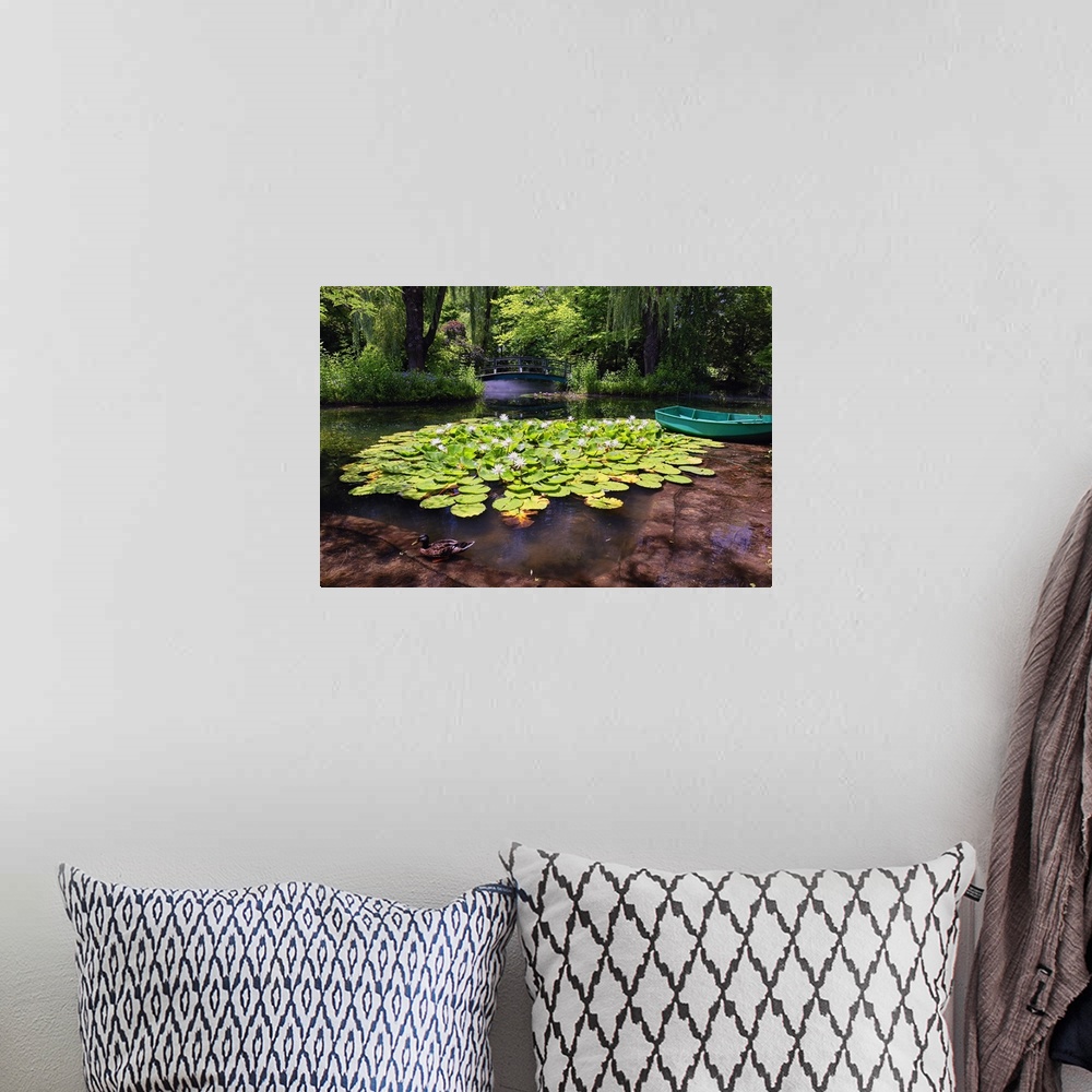 A bohemian room featuring A photograph of a pond with lily pads sitting on the surface of the water.