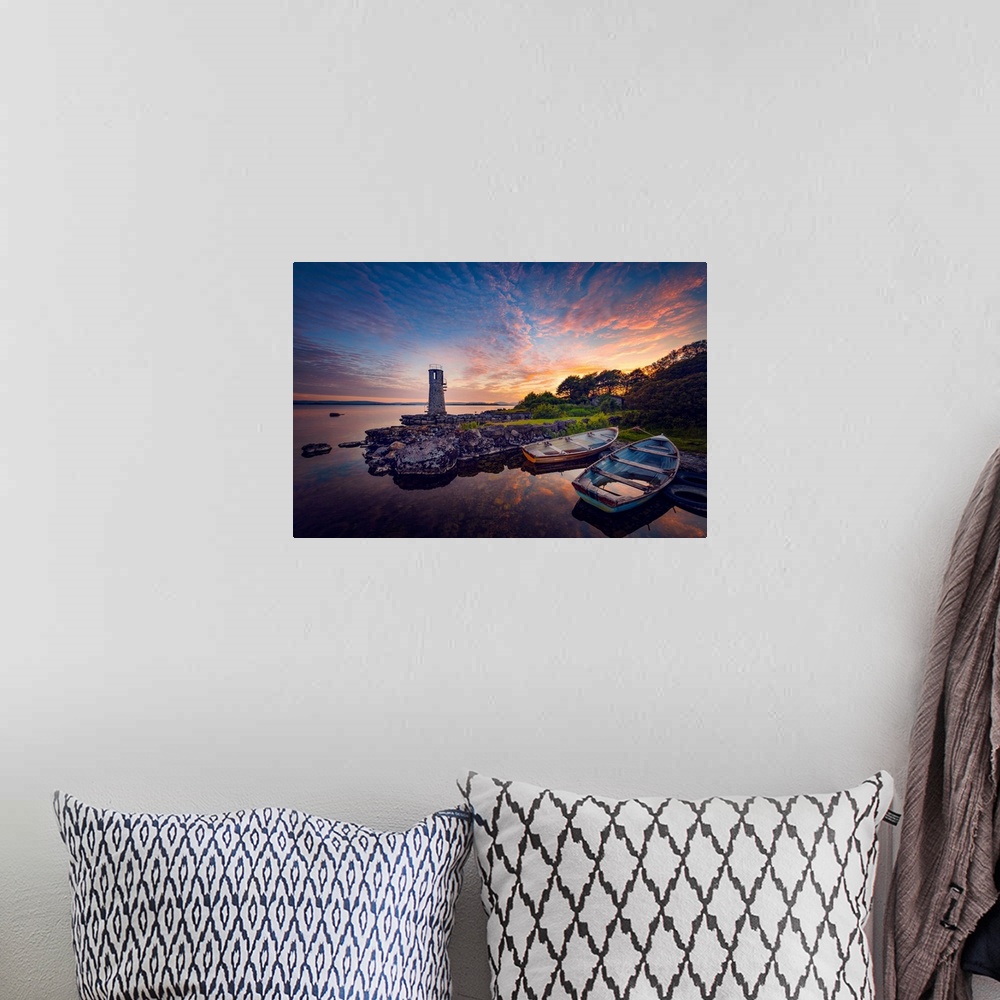 A bohemian room featuring Sunset in Ireland with rowing boats in the foreground around a lighthouse
