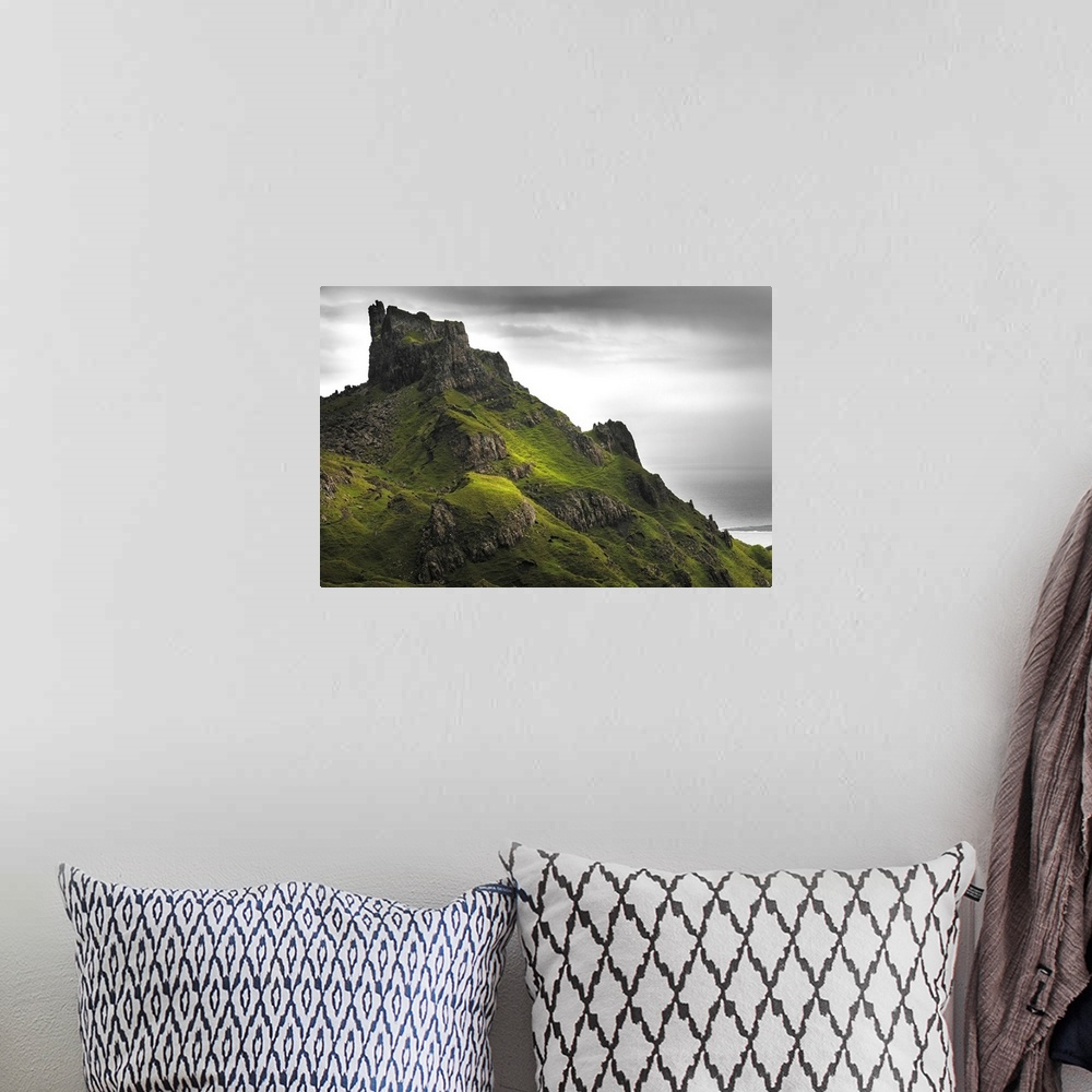 A bohemian room featuring Fine art photo of rocky spires on a green hill under a cloudy sky.