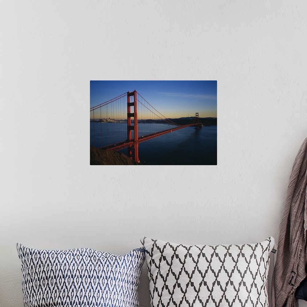 A bohemian room featuring Photograph of overpass crossing the ocean with city in the background.