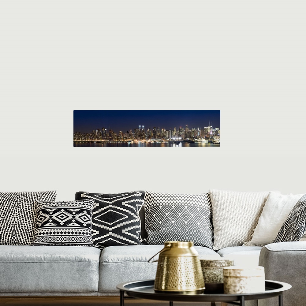 A bohemian room featuring This wall art is a panoramic photograph of the marvelous city skyline illuminated at night.