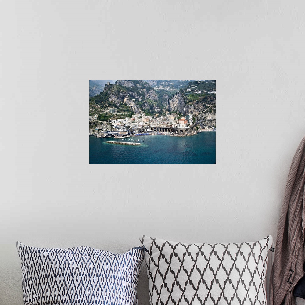 A bohemian room featuring This decorative wall art is an aerial photograph of an Italian village and harbor build into stee...