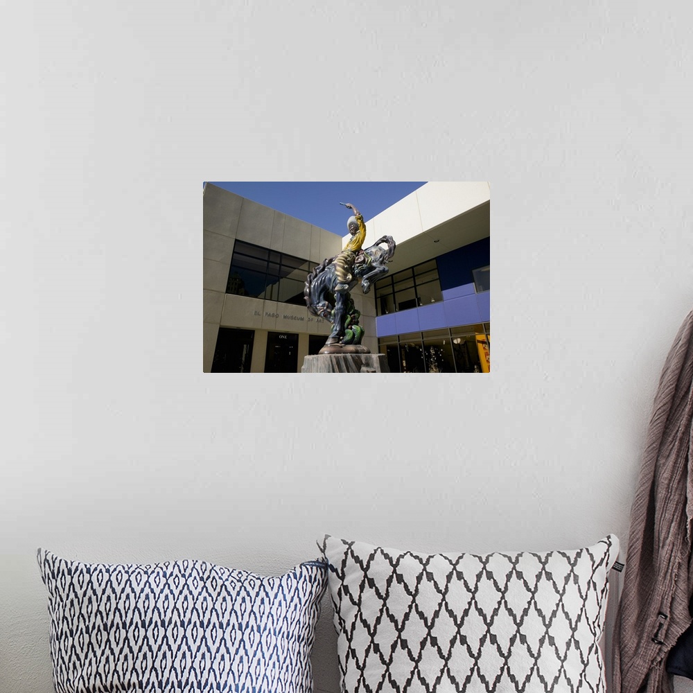 A bohemian room featuring Low angle view of a statue of a cowboy on a bucking bronco in front of a museum, El Paso Museum O...