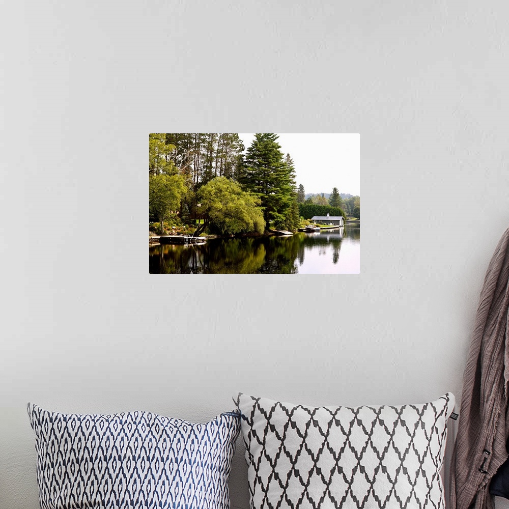 A bohemian room featuring Placid river with docks, boats and boathouse, Muskoka, Ontario, Canada