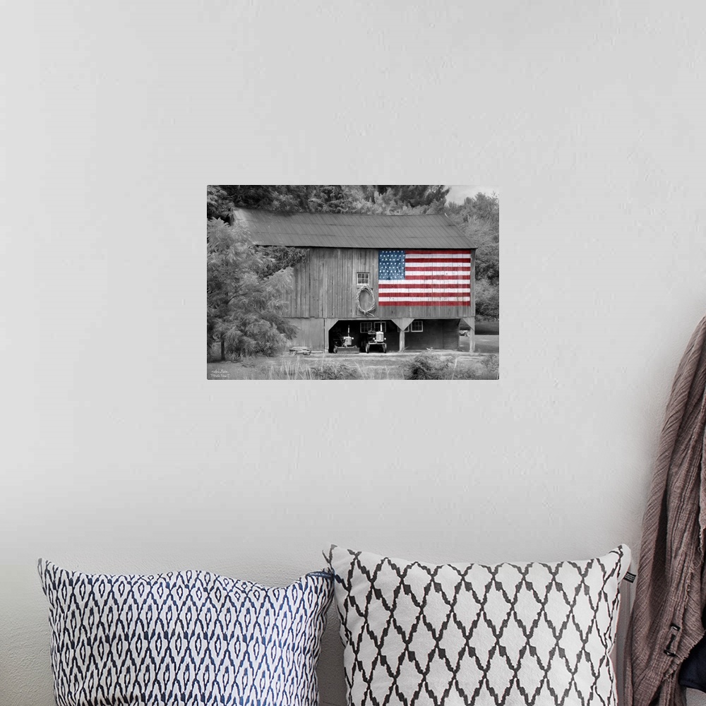 A bohemian room featuring Black and white photo of a barn with an American Flag in color painted on the side.