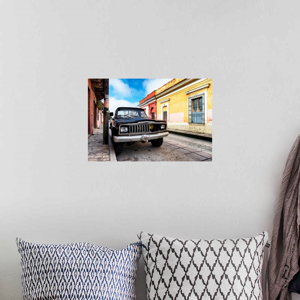 A bohemian room featuring Photograph of an old black Jeep parked on the side of a colorful street in Mexico. From the Viva ...