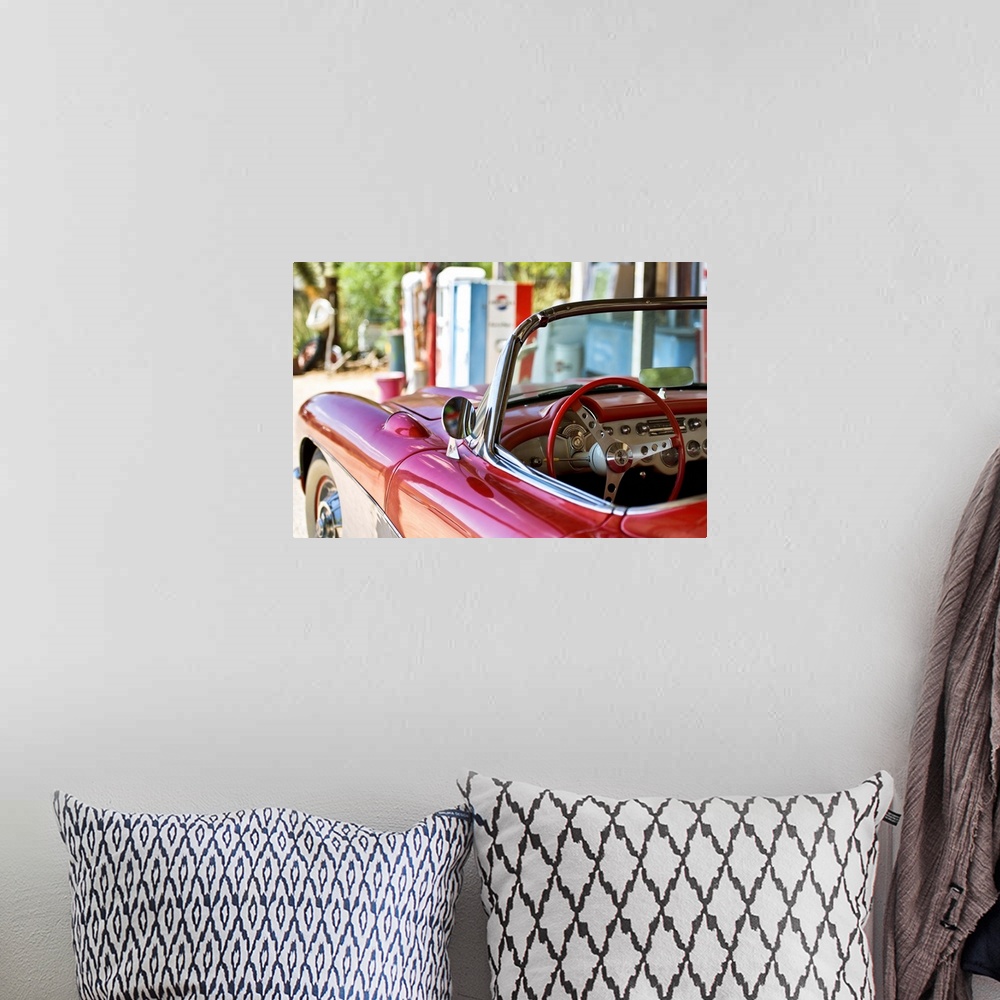 A bohemian room featuring The cherry red steering wheel stands out in this classic Chevy convertible on the beach.