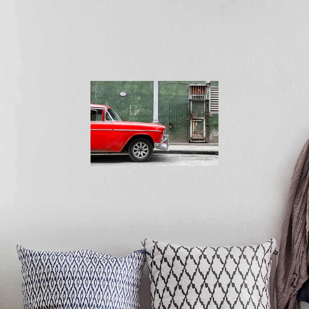 A bohemian room featuring Photograph of the front of a bright red vintage car with a dark green building in the background ...