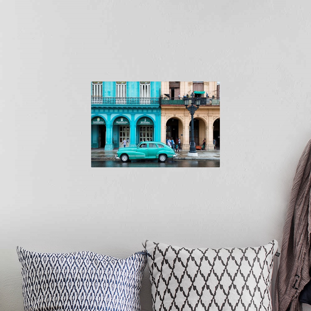 A bohemian room featuring Photograph of a turquoise vintage car parked outside of a bright blue building in downtown Havana.