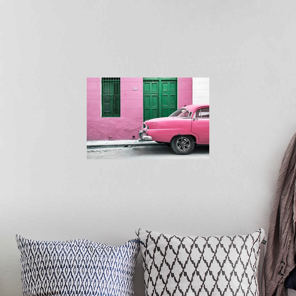 A bohemian room featuring Photograph of the back of a pink vintage car next to a matching facade with a green wooden door a...